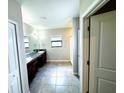 Bright bathroom featuring a double vanity with dark wood cabinets and tile flooring at 14050 Arbor Pines Dr, Riverview, FL 33579