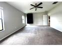 Spacious bedroom with gray carpet, a ceiling fan and natural light from two windows at 14050 Arbor Pines Dr, Riverview, FL 33579
