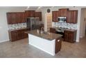 Bright kitchen features an island with granite counters, stainless steel appliances, and modern backsplash at 14050 Arbor Pines Dr, Riverview, FL 33579