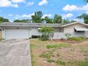 The house has a two-car garage and a well-manicured lawn at 1531 Picardy Cir, Clearwater, FL 33755