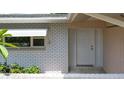 Front of a house with a white brick wall, and a white door at 1531 Picardy Cir, Clearwater, FL 33755