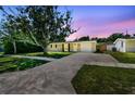 Exterior view of house with long driveway and green lawn at dusk at 1764 St Croix Dr, Clearwater, FL 33759