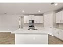 Bright kitchen features white cabinets, a center island with sink, and modern appliances at 17800 Solstice Ave, Venice, FL 34293