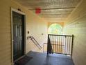 Hallway featuring a black door, exit sign and stairwell at 18267 Bridle Club Dr, Tampa, FL 33647