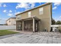 Back of home with screened lanai and stone pavers, ideal for outdoor living and entertaining guests at 19214 Early Violet Ne Dr, Tampa, FL 33647