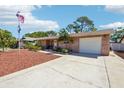 Charming single-story home with brick accents, a well-manicured lawn, and a spacious two-car garage at 2033 Whitney Dr, Clearwater, FL 33760
