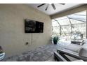 Covered patio with comfortable seating and a view of the screened-in pool area at 20647 Ovid Ln, Venice, FL 34293