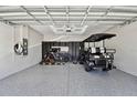 Spacious garage featuring a golf cart, electric car charger, epoxy floors and bike racks at 22287 Storybook Cabin Way, Land O Lakes, FL 34637