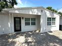 Close-up of the front exterior showing a white, one-story home and paver drive at 2315 Carroll Pl, Tampa, FL 33612