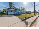 Exterior shot of light blue home, showcasing the driveway and lawn at 2418 N Links Ave, Sarasota, FL 34234