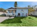 This light blue home offers a cozy front porch and landscaped front yard at 2418 N Links Ave, Sarasota, FL 34234