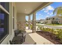 Inviting front porch with seating that overlooks the beautifully landscaped front yard at 33645 Elm Hill Br, Wesley Chapel, FL 33545