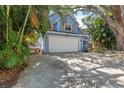 Two-story blue home with a two car garage and mature trees at 3710 W Tacon St, Tampa, FL 33629