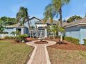 Beautiful home featuring a front yard with a fountain, lush landscaping, and mature trees at 4419 Swift Cir, Valrico, FL 33596