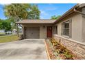 Single-story home with stone accents, driveway, lawn, landscaping, garage and covered entryway at 611 Limetree Dr, Oldsmar, FL 34677