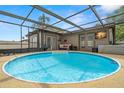 Screened-in pool with patio furniture, jacuzzi and TV at 611 Limetree Dr, Oldsmar, FL 34677