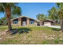 Charming single-story brick home featuring an expansive lawn and a detached two-car garage at 7169 Spruce Dr, Weeki Wachee, FL 34607