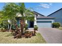 Well-manicured landscaping and trees accentuate this home's beautiful exterior and paver driveway at 7215 Wash Island Dr, Sun City Center, FL 33573