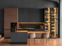 A sleek, modern kitchen featuring dark cabinetry, a marble backsplash, and contemporary seating with unique lighting at 77 Avonwood, Tampa, FL 33625