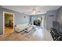 Bright living room with a sliding glass door to balcony, ceiling fan, and comfortable seating at 7700 92Nd St # 207, Seminole, FL 33777