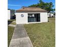 Exterior image of the community laundry building, with a walkway and landscaped lawn at 7701 Starkey Rd # 602, Seminole, FL 33777