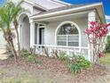 The front porch is adorned with white columns, vibrant greenery, and an arched window at 11414 Weston Course Loop, Riverview, FL 33579