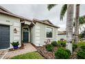Landscaped front entrance with brick walkway leading to a stylish door with decorative accents at 1155 Lawnview Ter, New Port Richey, FL 34655