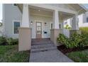 Inviting front porch with elegant columns and a stylish entrance, framed by lush landscaping at 1550 48Th N Ave, St Petersburg, FL 33703