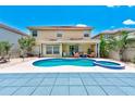Gorgeous backyard featuring a pool with spa, covered patio, and lush tropical landscaping at 2300 Hannah S Way, Dunedin, FL 34698