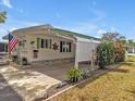 Inviting home exterior with a carport, an American flag, green shutters, and mature landscaping at 2331 Belleair Rd # 214, Clearwater, FL 33764