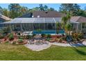 Relaxing backyard pool area with screened enclosure, patio furniture, and beautiful landscaping at 3109 Tarpon Woods Blvd, Palm Harbor, FL 34685