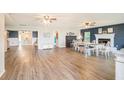 Open-concept living and dining room area featuring wood-look flooring, a cozy fireplace, and ample natural light at 4125 89Th E St, Palmetto, FL 34221