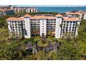 Stunning aerial view of a beachfront building with a terracotta roof and lush green landscaping at 4750 Dolphin Cay S Ln # 209, St Petersburg, FL 33711