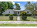 Inviting fenced front yard with a charming gate and lush green bushes complements this cozy, single-story home at 5148 3Rd N Ave, St Petersburg, FL 33710