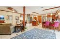 Spacious living room with tile flooring, a spiral staircase, kitchen, and custom wood trim at 515 Orange St, Palm Harbor, FL 34683