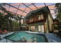 Stunning screened-in pool with attached spa and views of the home's balcony at 515 Orange St, Palm Harbor, FL 34683
