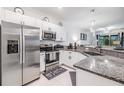 Modern kitchen featuring stainless steel appliances, granite countertops, and ample cabinet space at 6748 Ripple Pond Loop, Zephyrhills, FL 33541