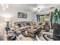 Comfortable living room featuring a large sectional sofa, decorative pillows, and stylish rug at 6748 Ripple Pond Loop, Zephyrhills, FL 33541