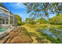 Scenic backyard featuring a serene pond with water lilies, providing a peaceful and natural view at 7051 Derwent Glen Cir, Land O Lakes, FL 34637