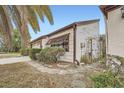 Side view of a charming home featuring a palm tree and beautiful stonework leading to an iron gate at 7509 Rocky Point Dr, Hudson, FL 34667