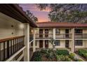 Condo exterior with red tile roof, upper and lower door wreaths, black railings, and mature landscaping at 110 Hammock Pine Blvd # 110, Clearwater, FL 33761