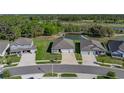 An aerial view of the property showcasing its location next to a pond and green surroundings at 11465 June Briar Loop, San Antonio, FL 33576