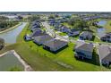 An aerial view of the property in a neighborhood with a pond, showcasing its location at 11465 June Briar Loop, San Antonio, FL 33576