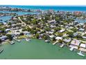 Stunning aerial view of a waterfront home with private dock and lush landscaping nestled by the serene water at 14043 E Parsley Dr, Madeira Beach, FL 33708