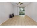 Bright living room featuring neutral walls, tile flooring, and a sliding glass door to a lanai at 1552 Pleasant Rd # J4, Bradenton, FL 34207