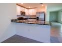 Modern kitchen features stainless steel appliances, granite countertops, and white cabinetry at 16805 Delia St, Wimauma, FL 33598