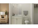 Cozy bathroom featuring a white vanity, marble countertop, gray towel, and warm wall color in room at 18448 Serene Lake Loop, Lutz, FL 33548