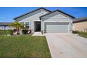 Inviting single-Gathering home with a two-car garage, lush green lawn, and vibrant landscaping at 2232 Harris Hawk, Ruskin, FL 33570