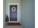 Welcoming front door adorned with a floral wreath and a charming 'Home Sweet Home' doormat at 2232 Harris Hawk, Ruskin, FL 33570