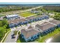 Aerial view of an attractive community with a pond, modern townhomes, and convenient parking at 2895 Deer Pine Trl, Land O Lakes, FL 34638